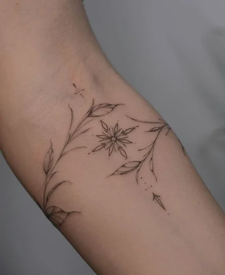 Fine line minimalist floral vine tattoo design for women on forearm