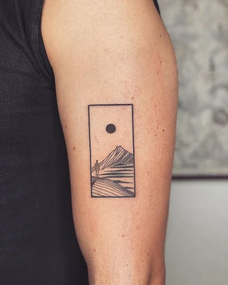 Minimalist fine line mountain and sun tattoo design for men on upper arm