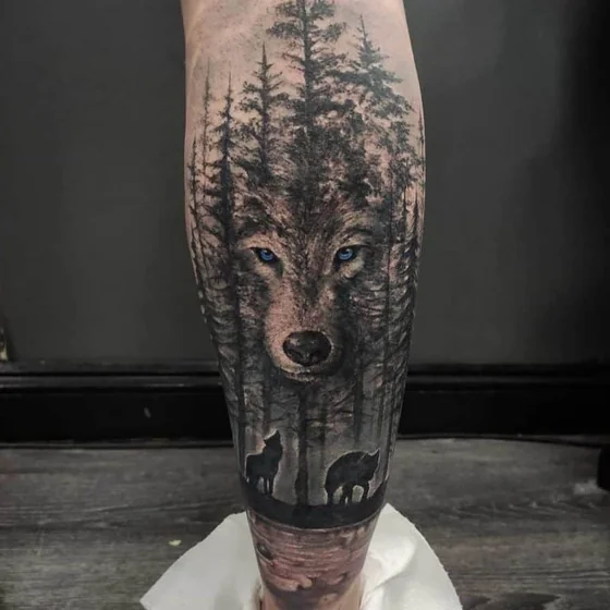 Realistic wolf and forest tattoo idea for men and women on calf
